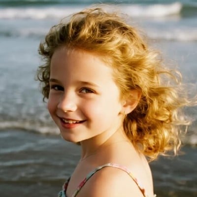 The sample image of a little girl with short golden curls walking on the beach