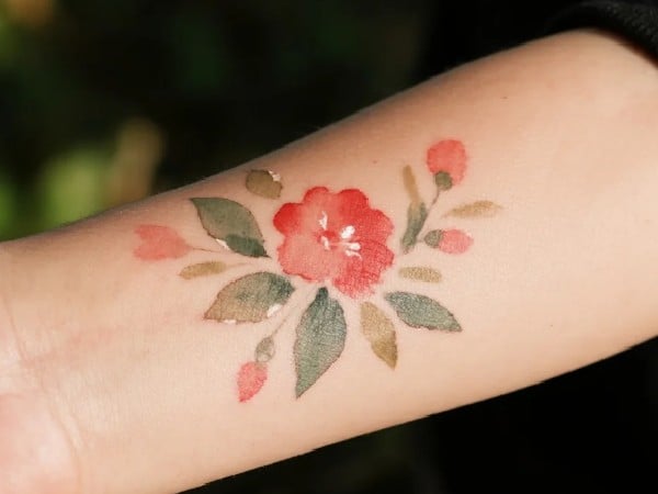 Get a red watercolor flower tattooed on your arm